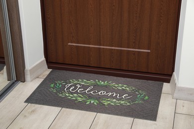 Photo of Beautiful doormat with word Welcome on floor near entrance