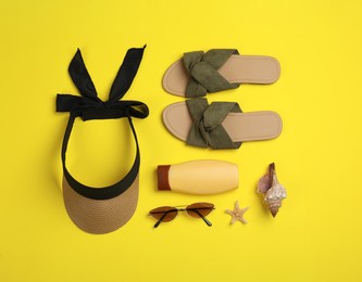 Photo of Flat lay composition with beach accessories on yellow background