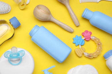 Flat lay composition with baby care products and accessories on yellow background