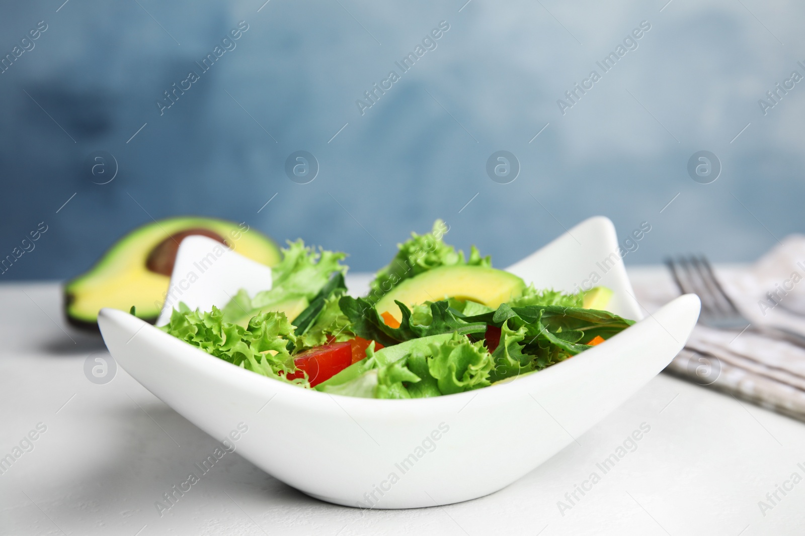 Photo of Delicious avocado salad in bowl on table