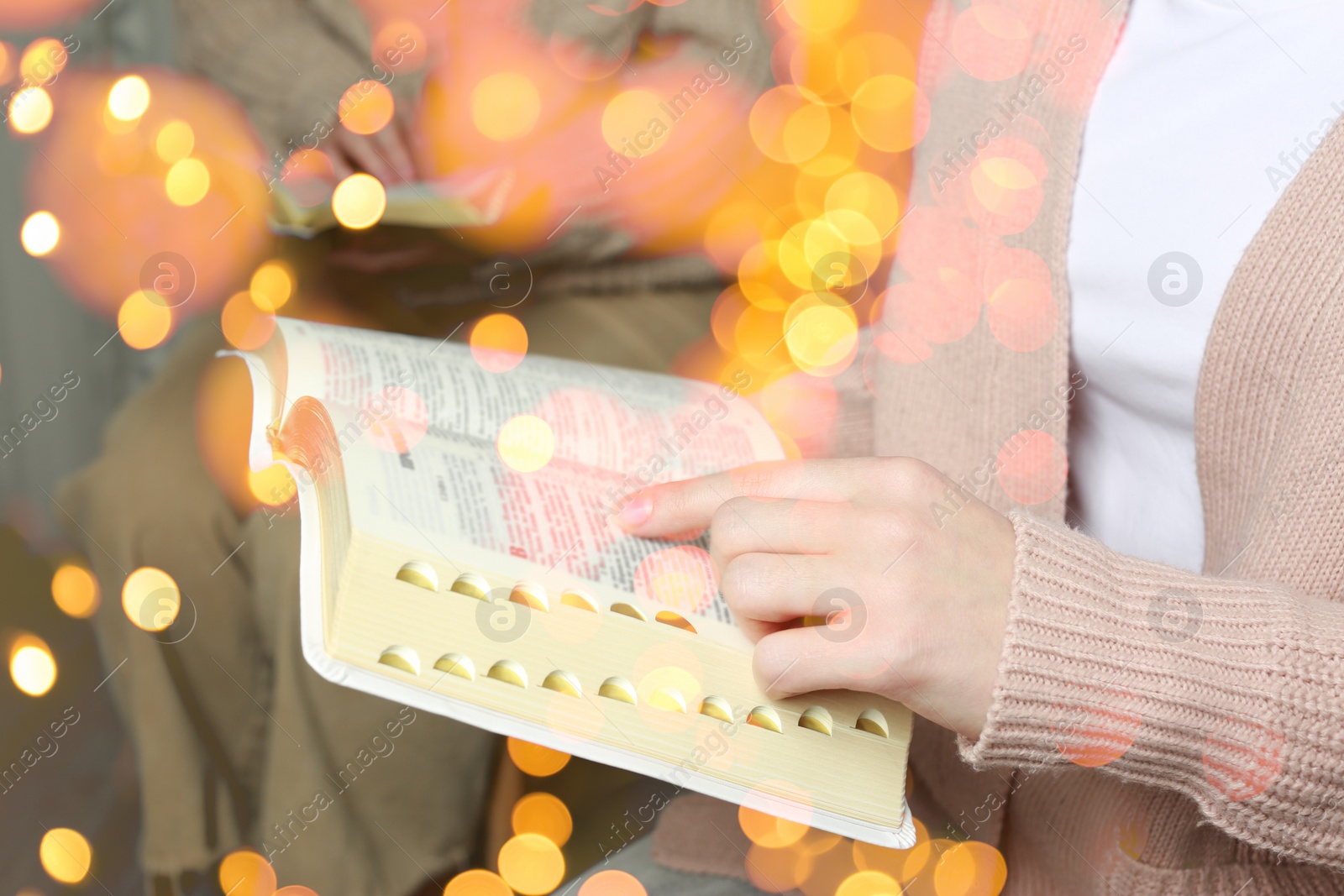 Image of Woman reading Bible, closeup view. Bokeh effect