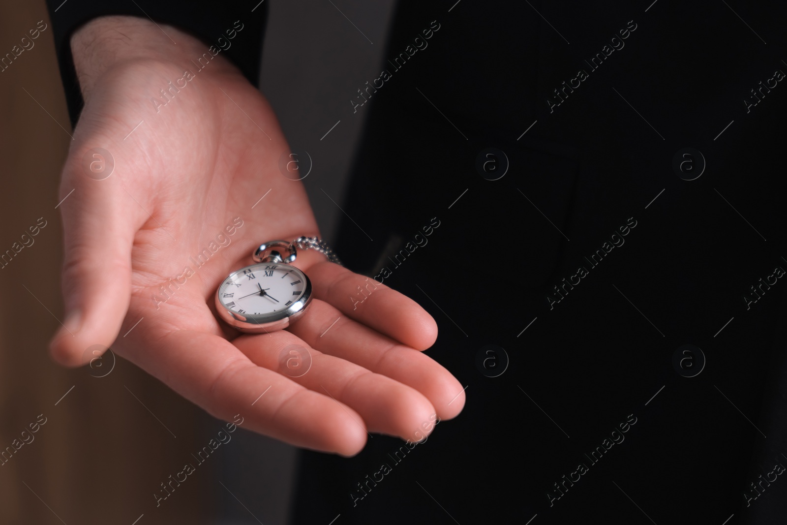 Photo of Man holding chain with elegant pocket watch, closeup