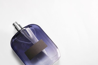 Luxury men`s perfume in bottle on white background, top view. Space for text