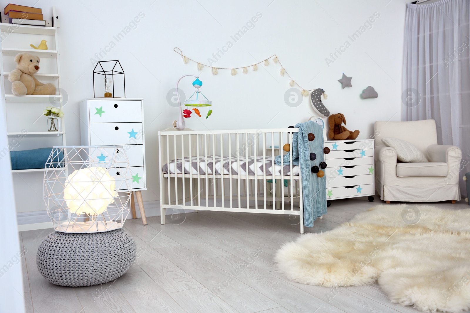 Photo of Cozy baby room interior with crib and armchair