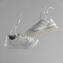 Photo of Pair of stylish white sneakers on light grey background. Space for text