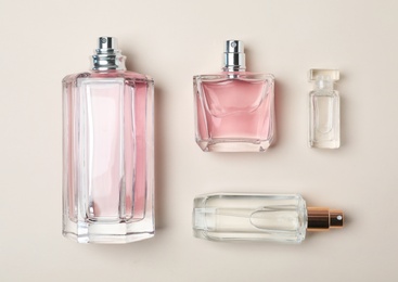 Photo of Bottles of perfume on light background, top view