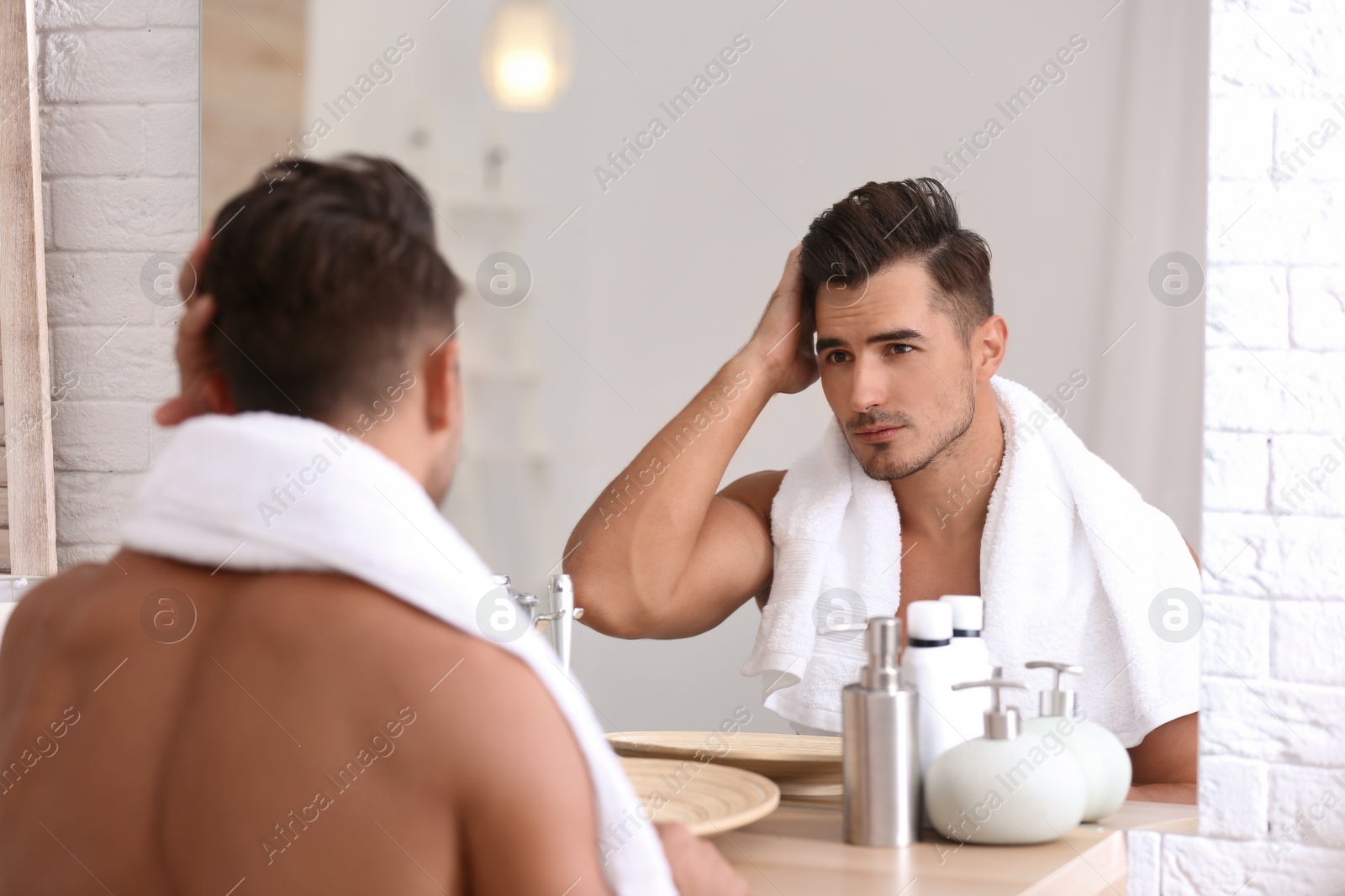 Photo of Young man with stubble ready for shaving near mirror in bathroom