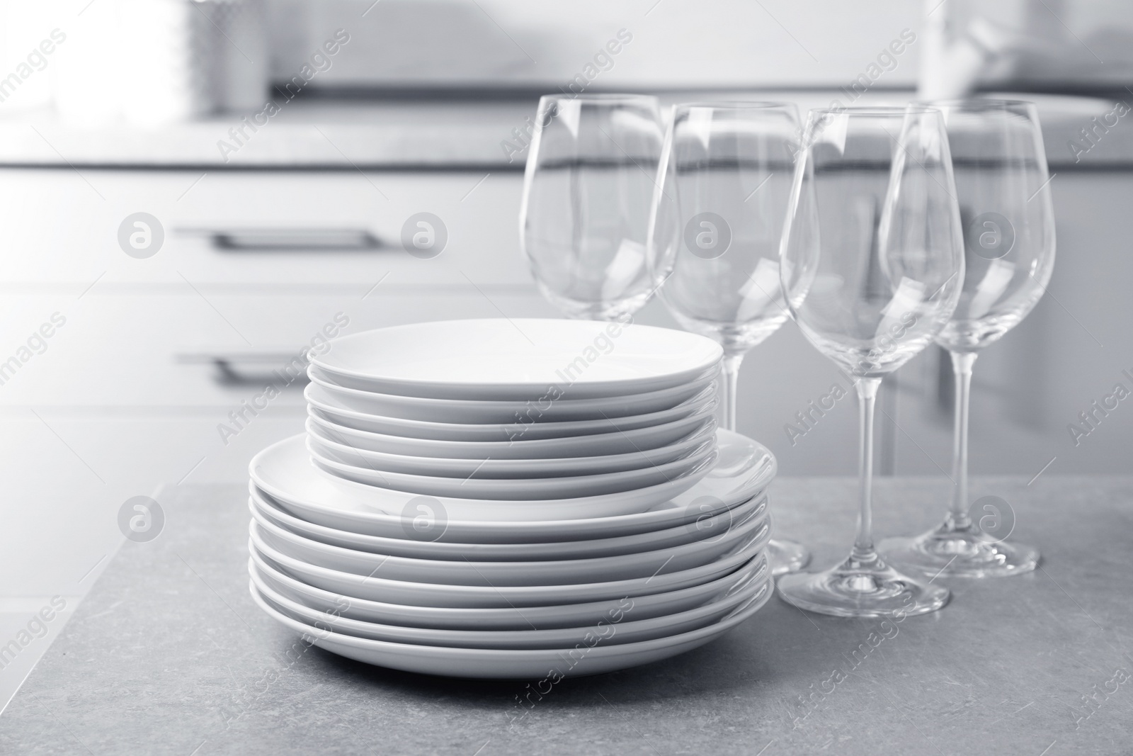 Photo of Set of clean dishes on table in kitchen