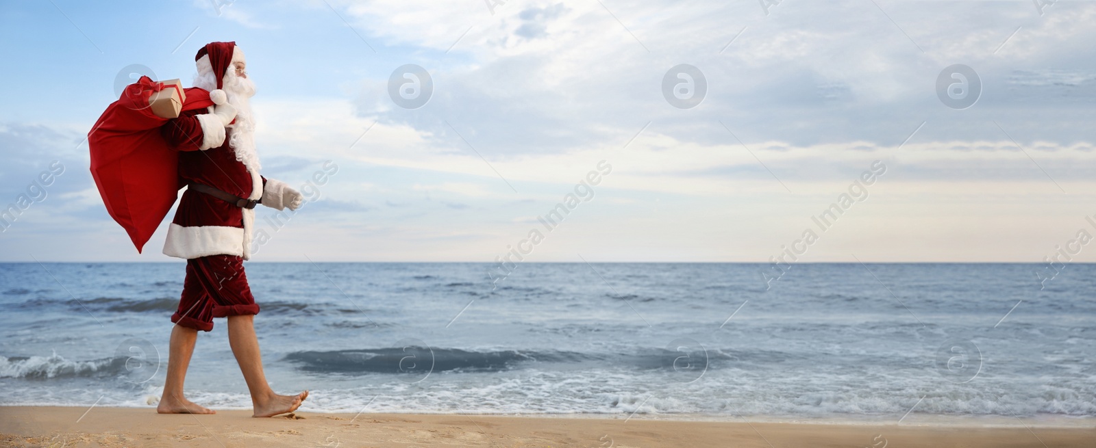 Image of Santa Claus with bag of presents on beach, banner design. Christmas vacation