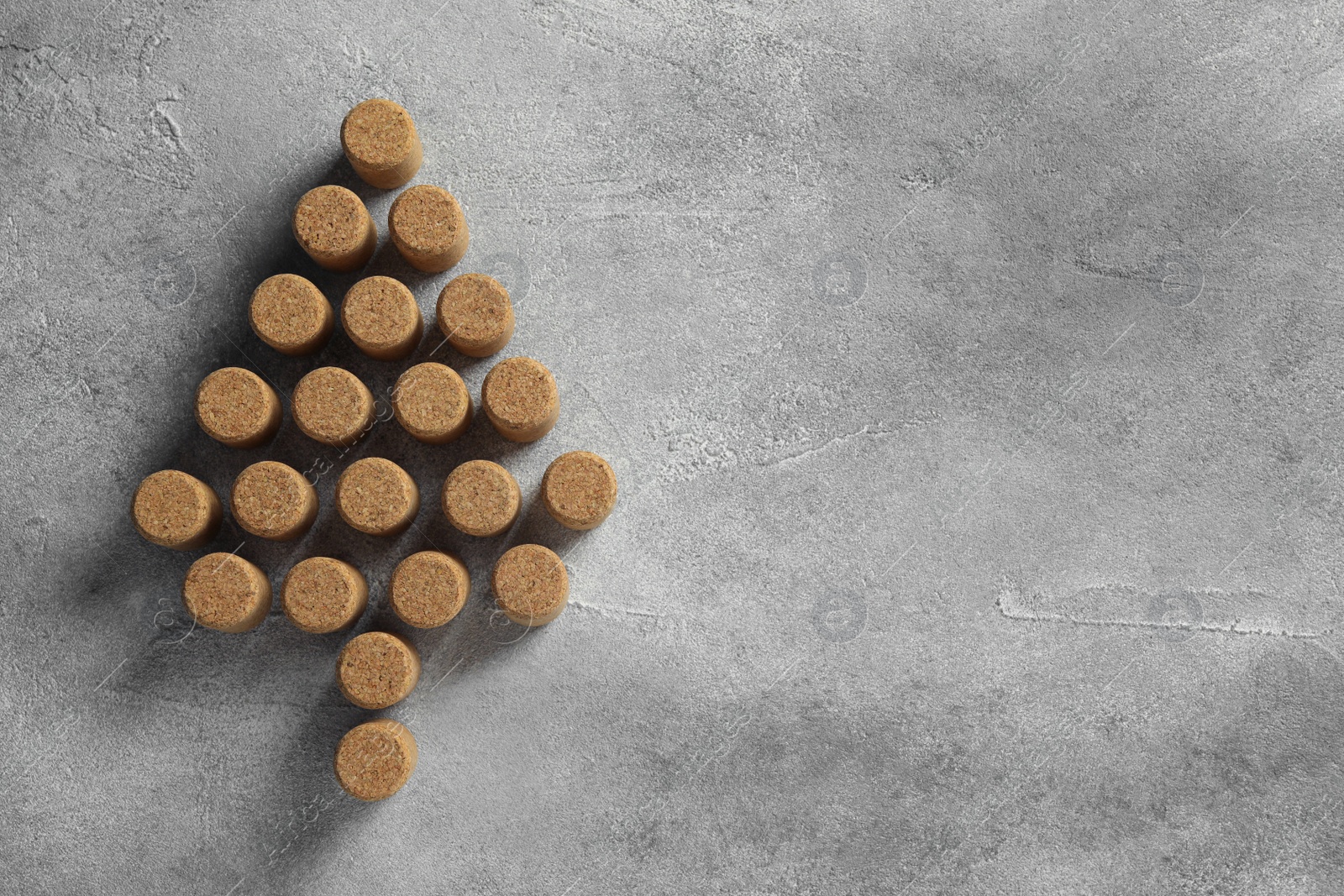 Photo of Christmas tree made of wine corks on grey table, top view. Space for text