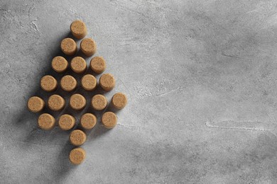 Photo of Christmas tree made of wine corks on grey table, top view. Space for text