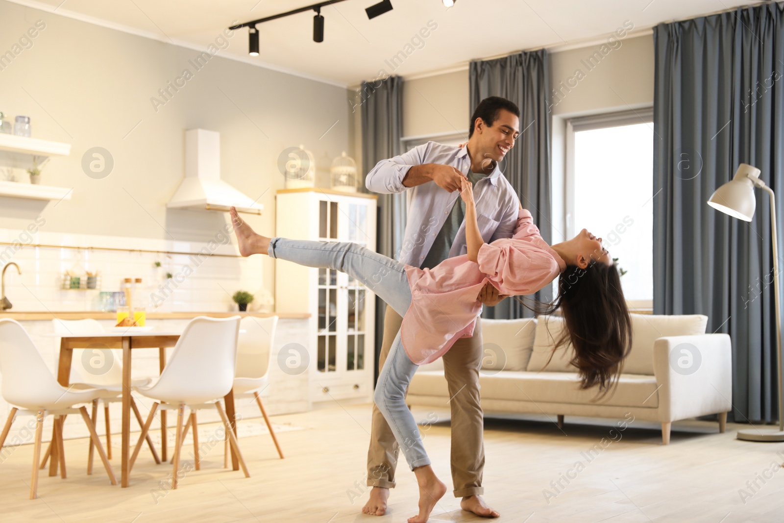 Photo of Lovely young interracial couple dancing at home