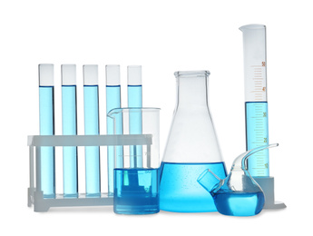 Photo of Different laboratory glassware with light blue liquid isolated on white