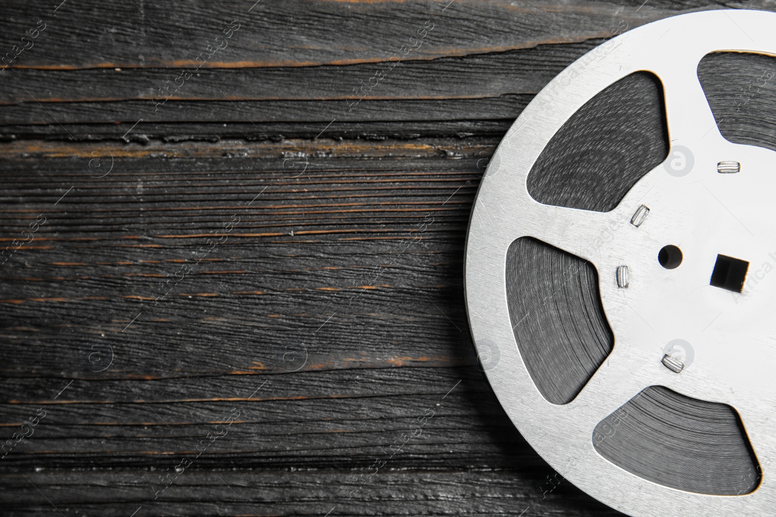 Photo of Movie reel on wooden background, top view with space for text. Cinema production