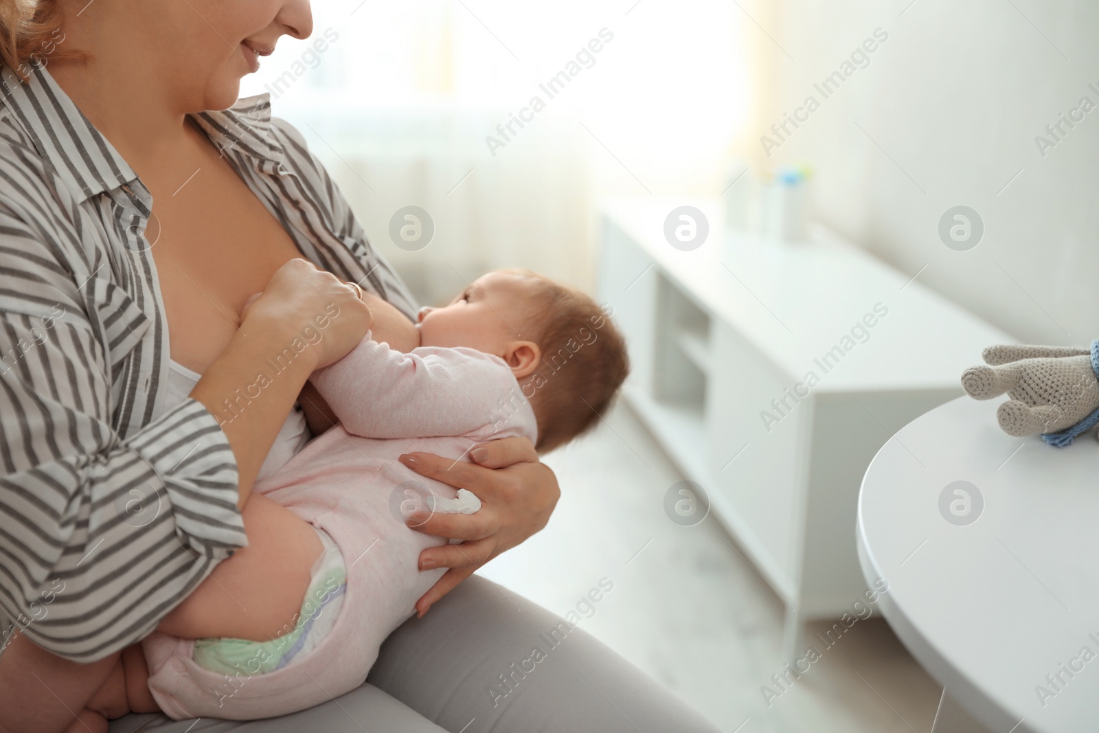 Photo of Young woman breastfeeding her baby at home