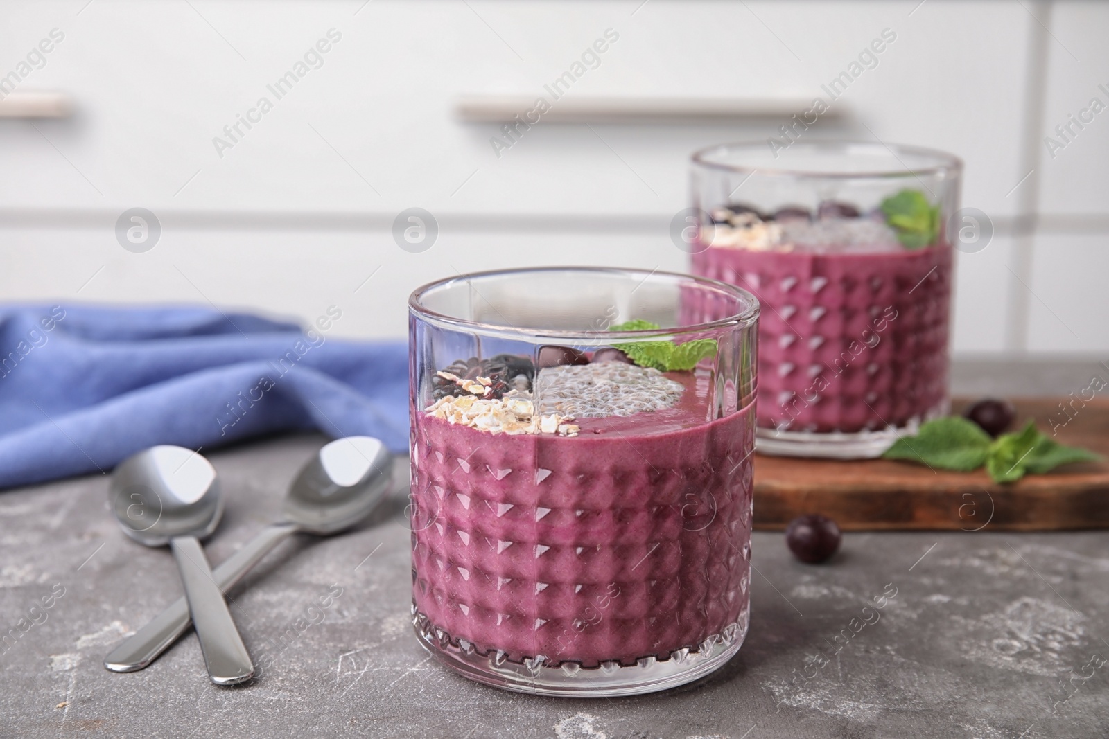 Photo of Glasses with tasty acai smoothie on gray table