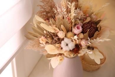 Photo of Bouquet of dry flowers and leaves indoors