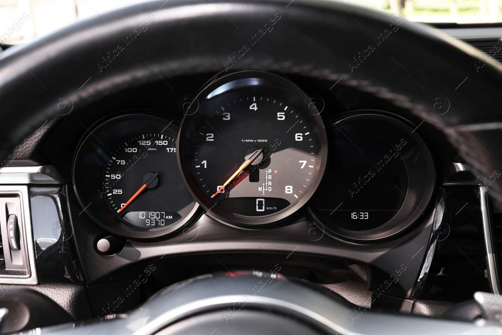 Photo of Steering wheel, speedometer and tachometer inside of modern car, closeup