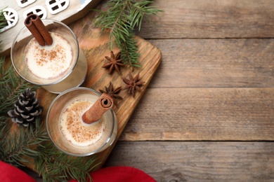 Photo of Delicious Christmas liqueur on wooden table, flat lay. Space for text