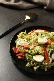 Photo of Delicious salad with Chinese cabbage and quail eggs served on black table, closeup