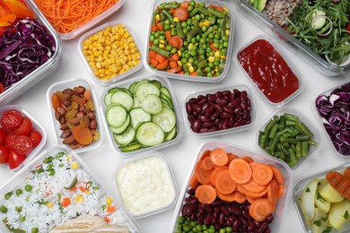 Photo of Set of containers with fresh food on white table, flat lay