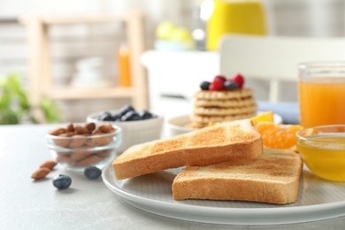 Photo of Delicious breakfast with toasted bread served on light table indoors