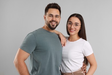 Beautiful couple wearing glasses on light gray background