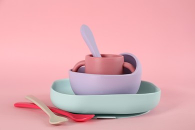 Photo of Set of plastic dishware on pink background. Serving baby food