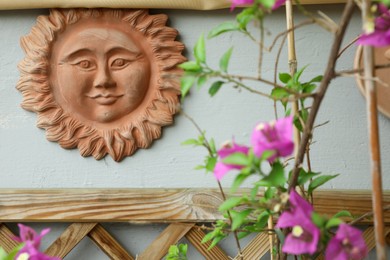 Photo of Beautiful decorative ceramic sun on light wall