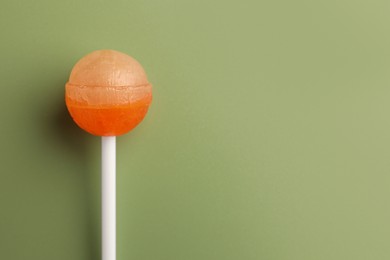 Photo of Tasty lollipop on green background, top view. Space for text