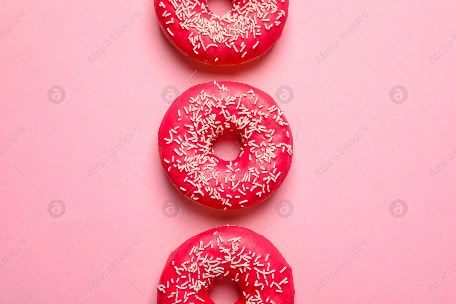 Photo of Delicious glazed doughnuts on color background, top view