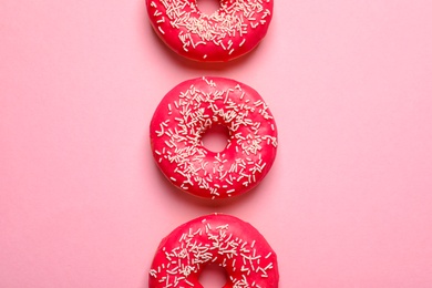 Delicious glazed doughnuts on color background, top view