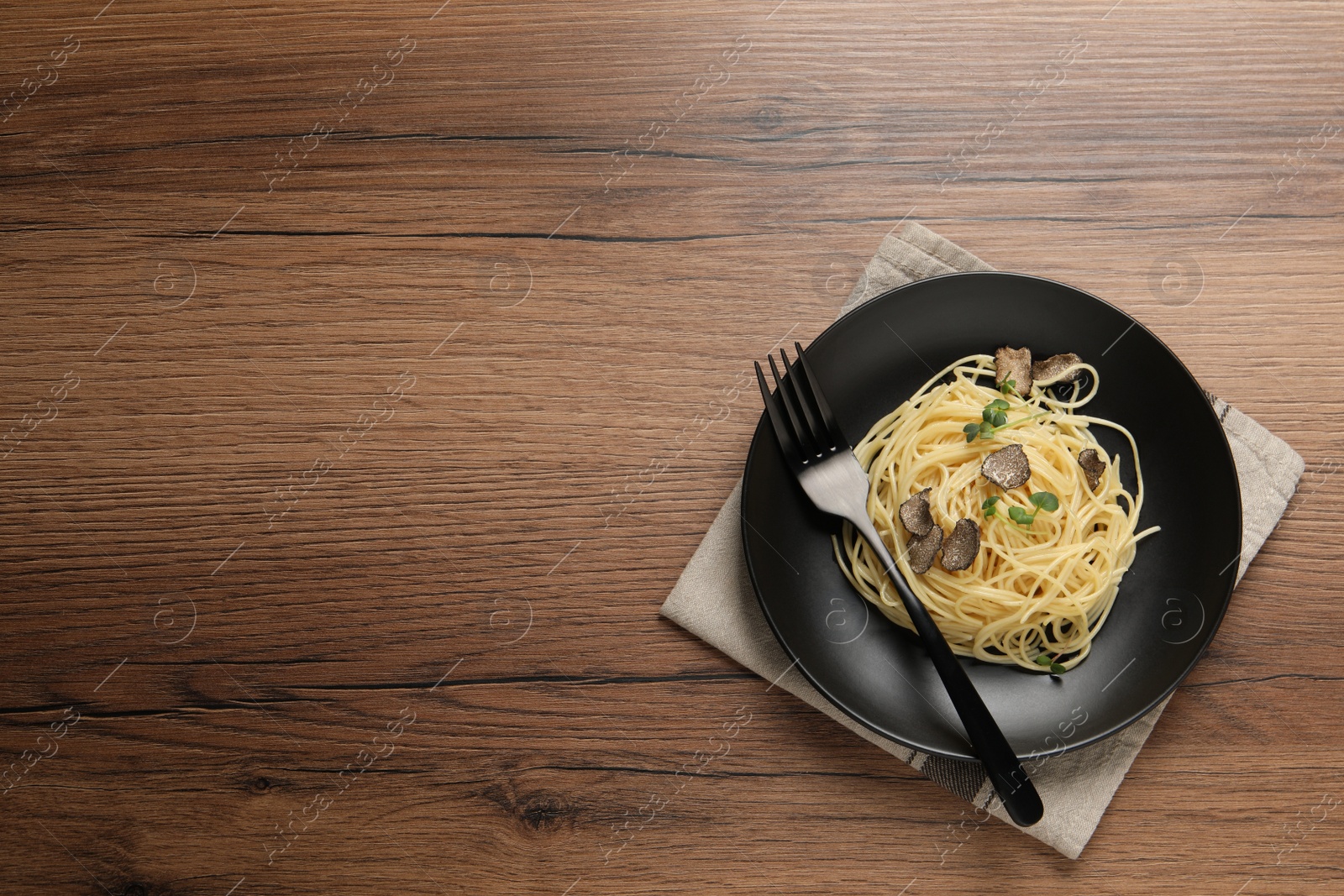 Photo of Tasty spaghetti with truffle on wooden table, top view. Space for text