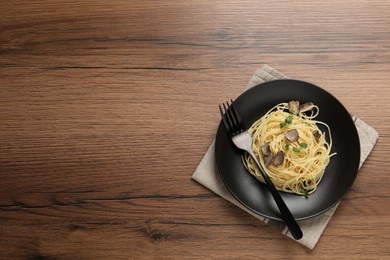 Photo of Tasty spaghetti with truffle on wooden table, top view. Space for text