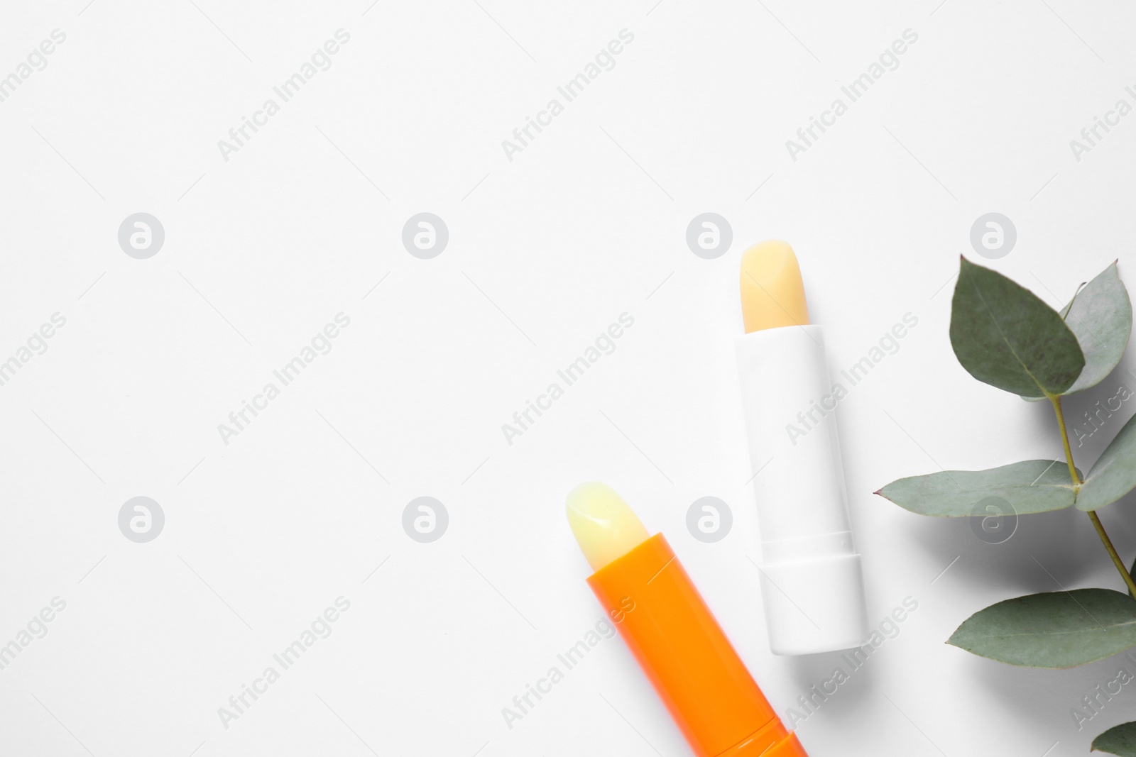 Photo of Hygienic lipsticks on white background, top view