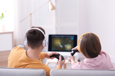 Photo of Young couple playing video games at home