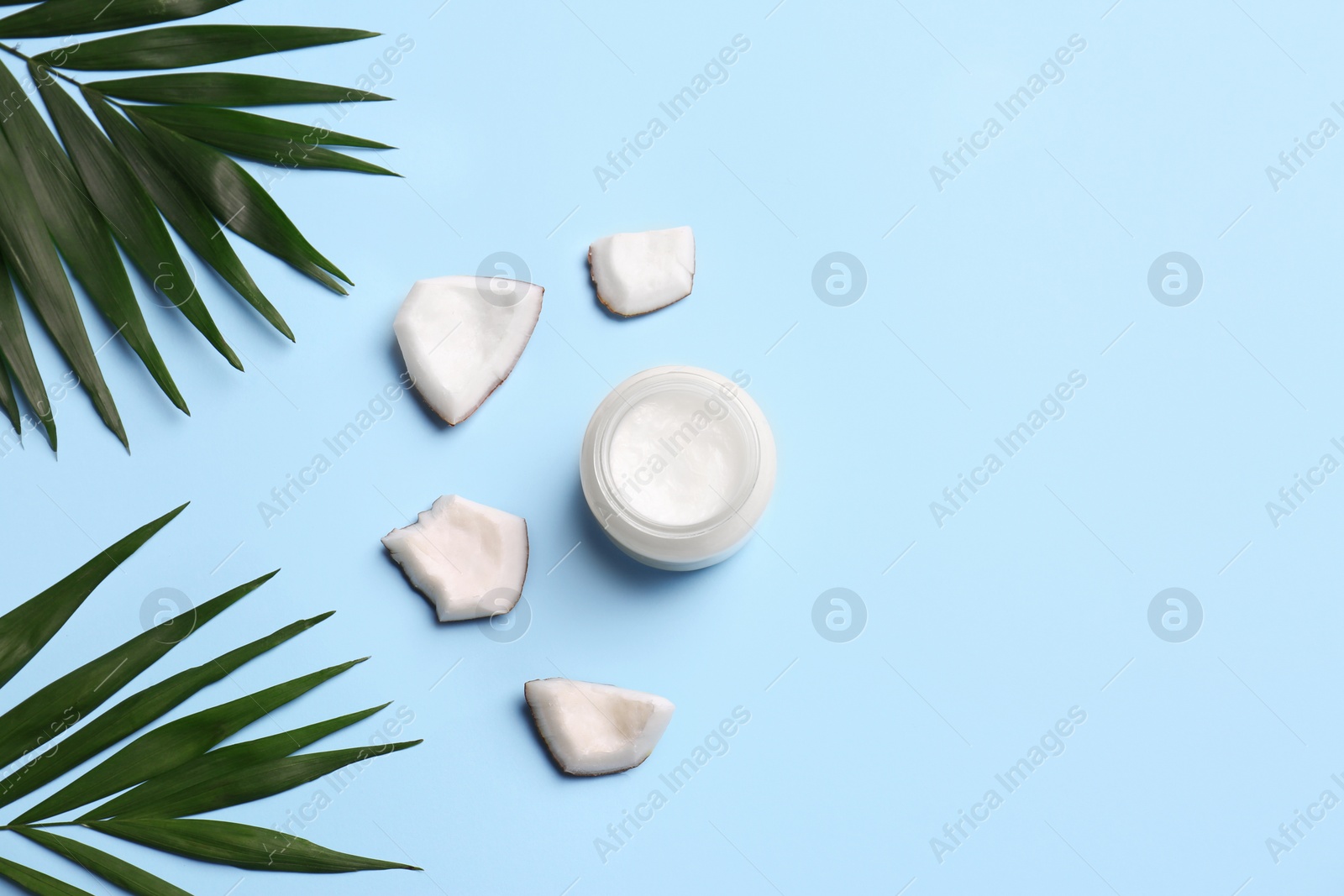 Photo of Jar with coconut oil and nut pieces on color background