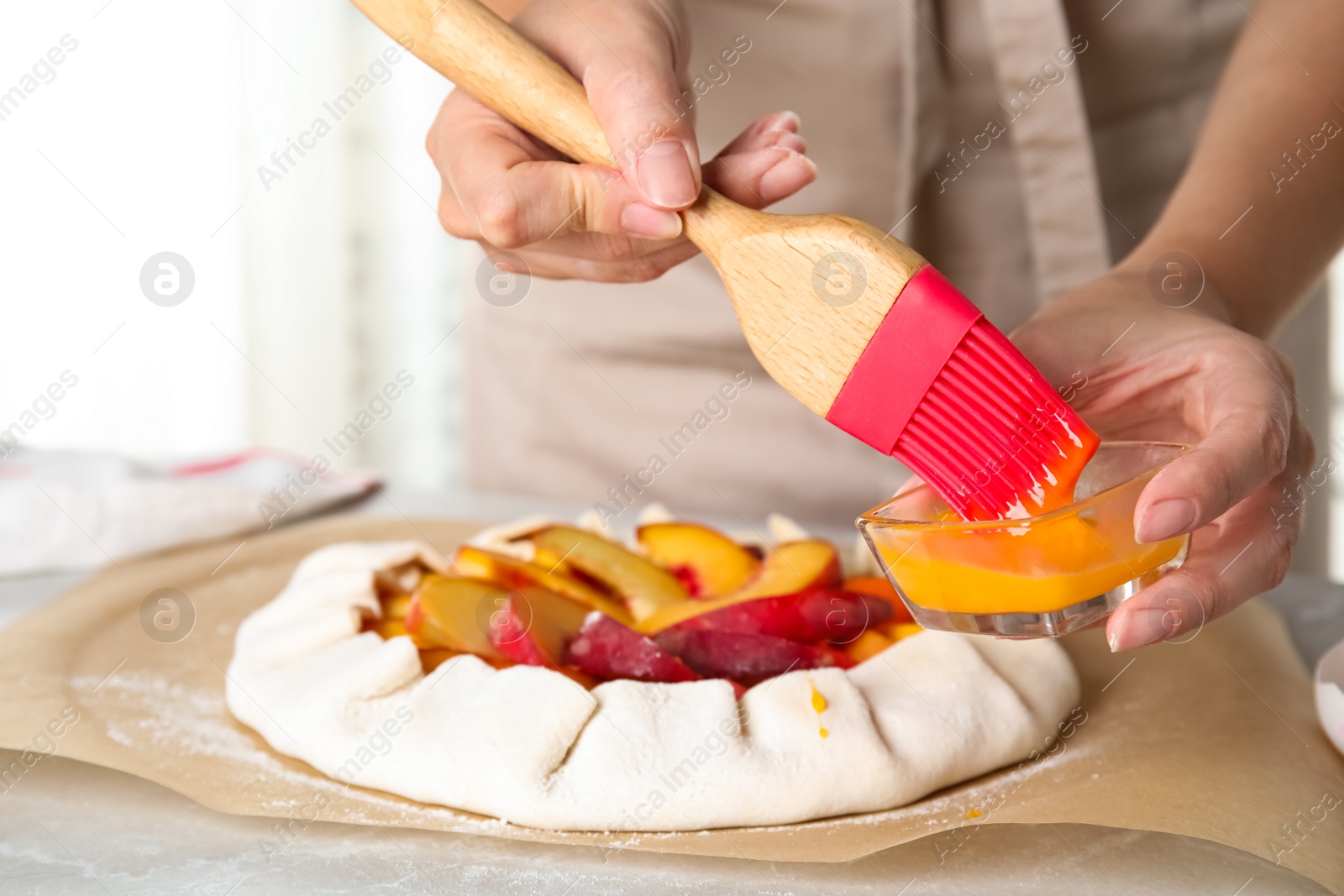 Photo of Woman making peach pie at kitchen table, closeup