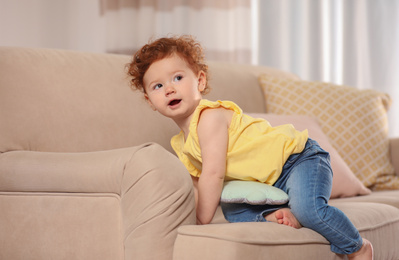 Photo of Portrait of cute little child on sofa at home