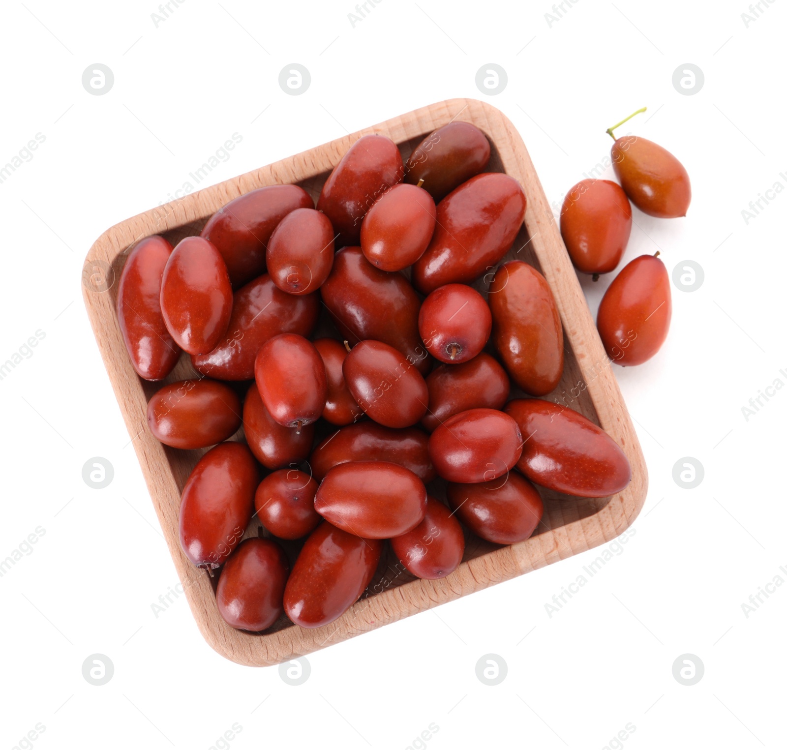 Photo of Wooden plate of ripe red dates on white background, top view