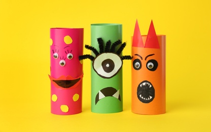 Photo of Funny monsters on yellow background. Halloween decoration