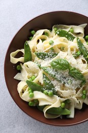 Photo of Delicious pasta with green peas and cheese on grey table, top view