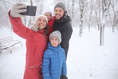 Happy family taking selfie outdoors on winter day. Christmas vacation