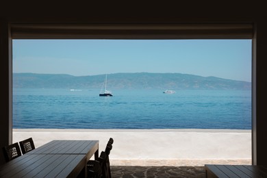 Photo of Beautiful seascape with boats and distant shore, view from closed terrace