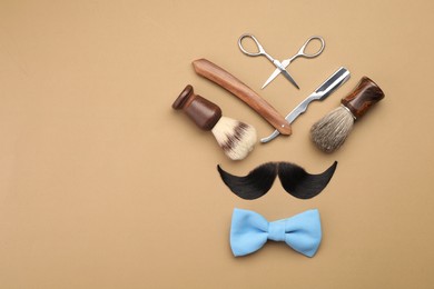 Photo of Artificial moustache and barber tools on beige background, flat lay. Space for text
