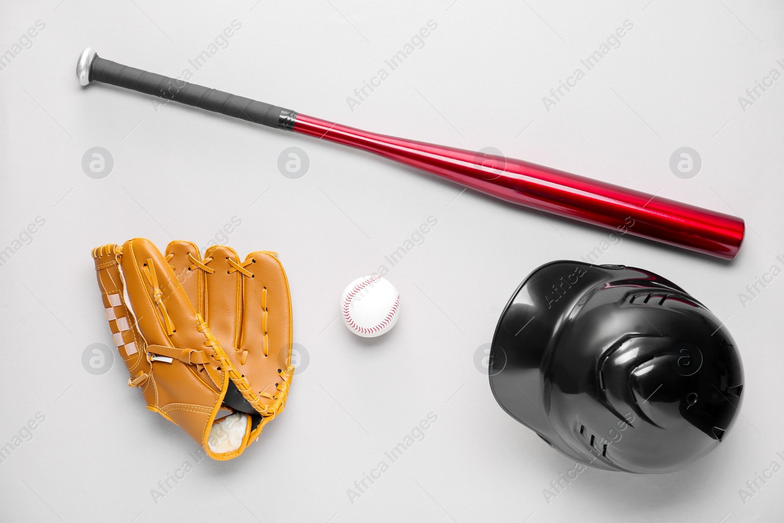 Photo of Baseball glove, bat, ball and batting helmet on light grey background, flat lay