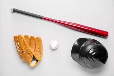 Baseball glove, bat, ball and batting helmet on light grey background, flat lay