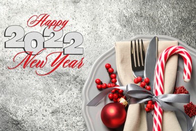 Image of Happy New 2022 Year! Beautiful table setting on grey background, top view 