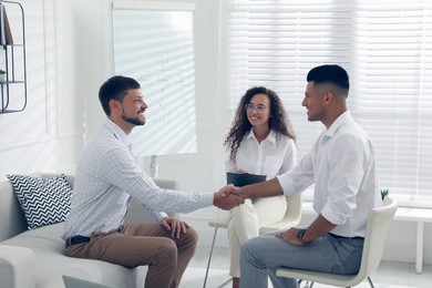 Photo of Boss shaking hands with new coworker during job interview in office