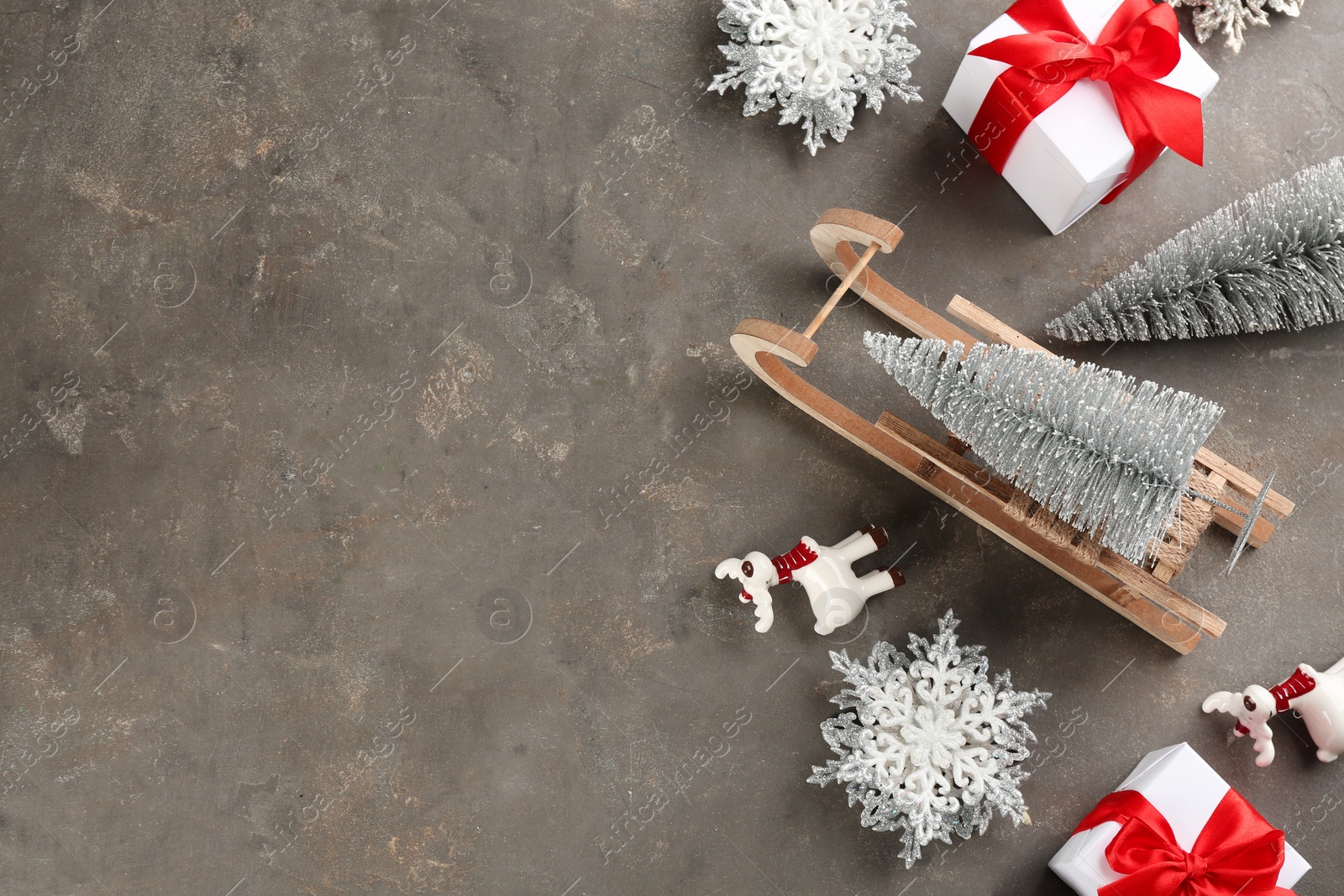 Photo of Beautiful Christmas composition with miniature sleigh on grey table, flat lay. Space for text